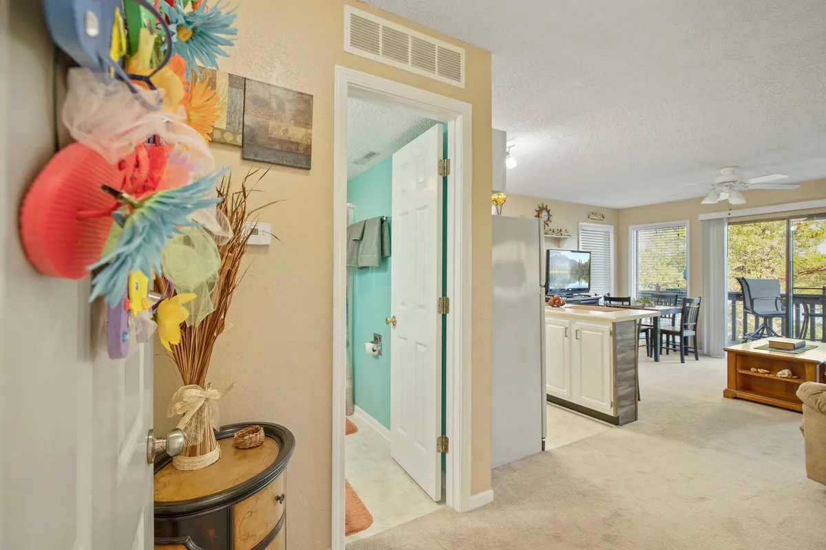 An inviting and cheerful interior space that seamlessly blends the open kitchen, dining area, and living room. Colorful decorations, abundant natural light, and access to a balcony create a lively yet comfortable environment for family gatherings and shared experiences.